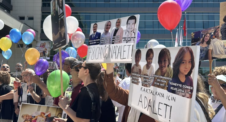 Crowd of protesters in an urban plaza holding large posters with photos of people and the word ADALET (justice), plus colorful balloons.