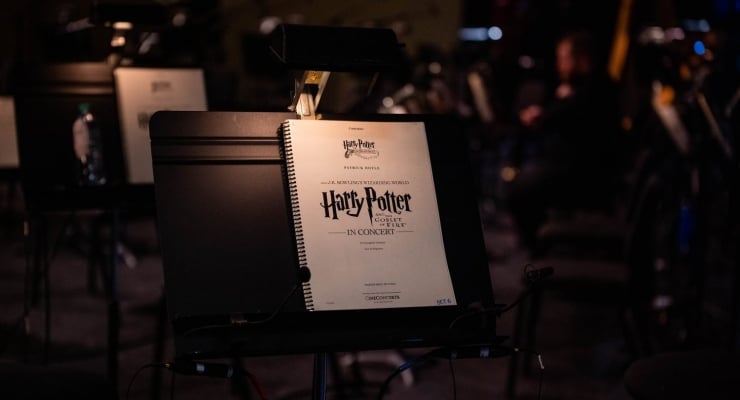 Sheet music titled 'Harry Potter in Concert' on a stand during a dim concert setting.