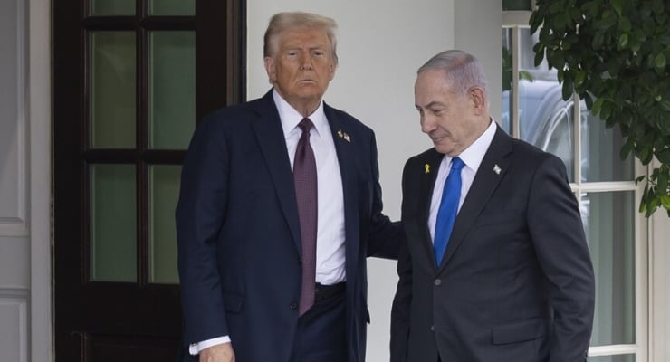 Donald Trump and Benjamin Netanyahu stand side by side outside a doorway in dark suits, Trump with his hand on Netanyahu's shoulder.