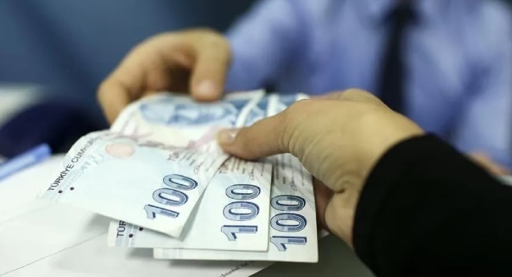 Two hands exchanging Turkish 100-lira banknotes during a cash transaction, close up on the bills.