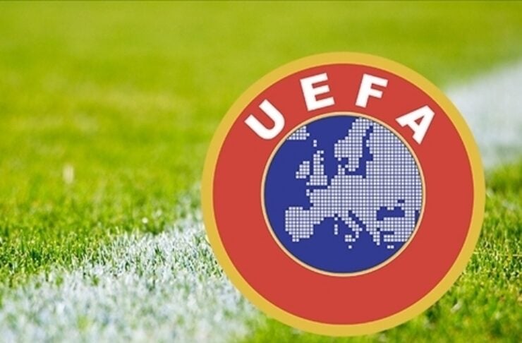UEFA emblem on a grassy soccer field with a white line nearby.