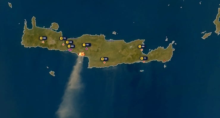 Satellite map of a large island with numbered markers and a long smoke plume rising from the southern coast.
