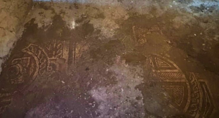 Circular, intricate stone carvings partially visible on a dusty floor surface
