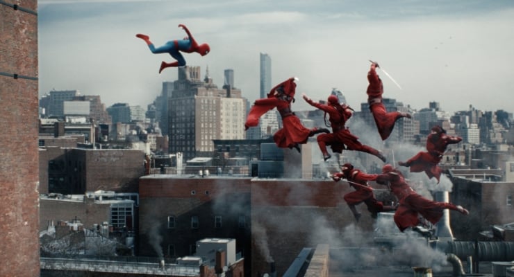 Superhero in blue and red soars through the air as several figures in red cloaks leap between rooftops over a city skyline.